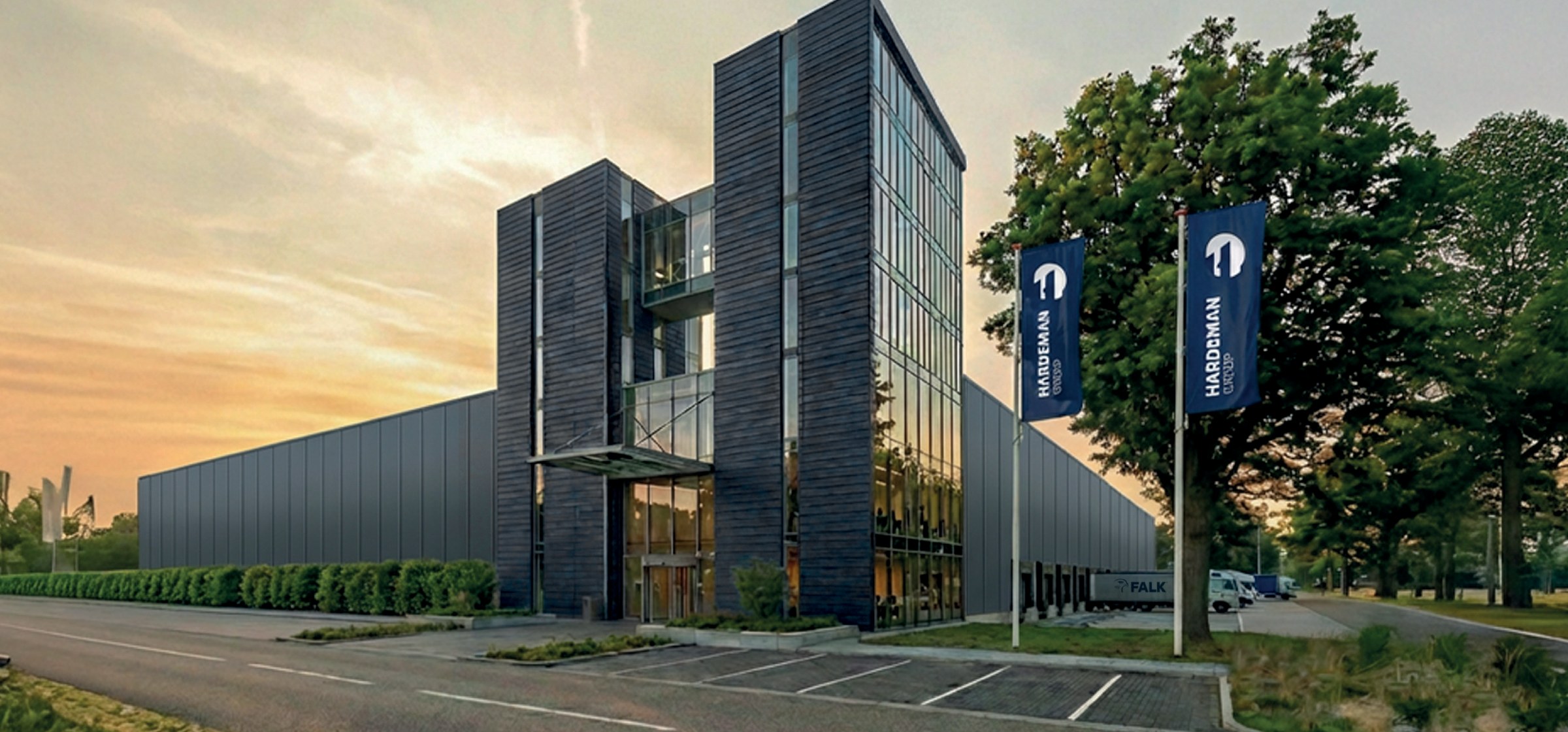 Hoofdkantoor van de Hardeman Groep met vlaggen bij zonsondergang